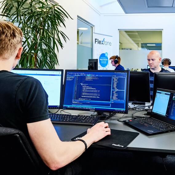Flexfones kontor hvor medarbejdere arbejder ved computere og programmere Flexfones kontor hvor medarbejdere arbejder ved computere og programmere